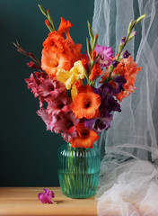 bouquet of colorful gladioli in a blue vase.