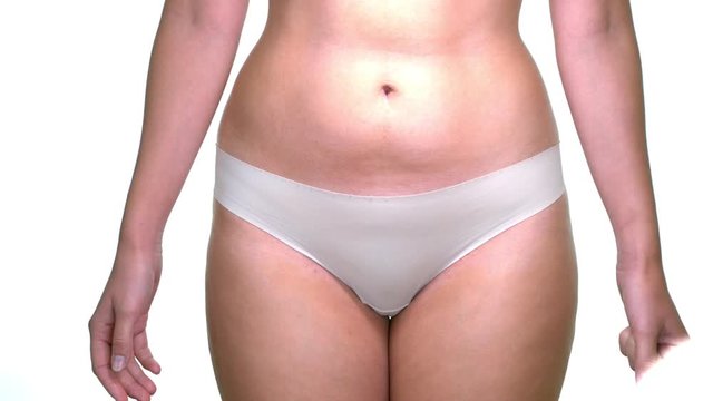 Close up shot of woman covering her pelvis area while wearing panties on isolated white background