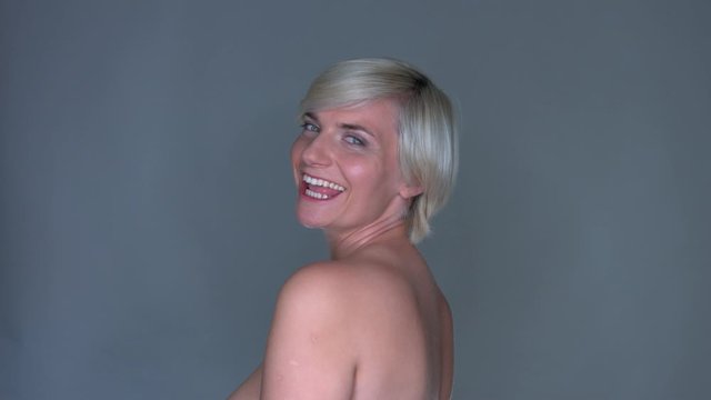 Happy smiling blonde woman looking at the camera on isolated gray background 