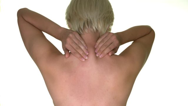  Young woman rubbing her neck and showing that she has back pain. Rack focus