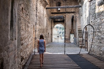 Fototapeta na wymiar junge Frau gehend von hinter in alter Burg