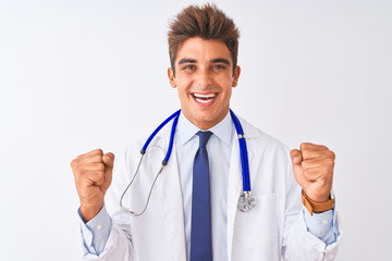 Fototapeta premium Young handsome doctor man wearing stethoscope over isolated white background celebrating surprised and amazed for success with arms raised and open eyes. Winner concept.