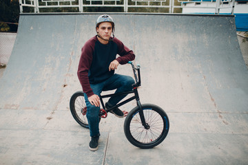 Professional young sportsman cyclist with bmx bike at skatepark