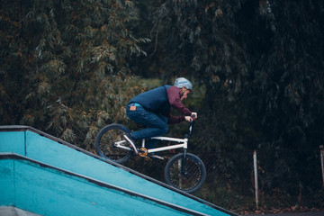 Professional young sportsman cyclist with bmx bike at skatepark