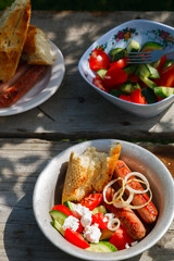BBQ. Village lunch. grilled sausages with vegetable salad, onion and grilled bread.