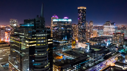 Aerial view of Jersey City skyscrapers by night from a drone flying above Hudson river.