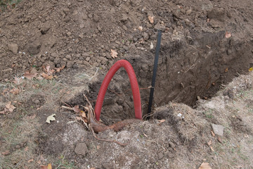 Laying water pipes and electric cable. Trench for laying pipes. Dug a pit with pipes for water, electrics.