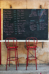 Greek menu with price on chalkboard at street cafe
