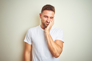 Young handsome man wearing casual white t-shirt over isolated background thinking looking tired and bored with depression problems with crossed arms.