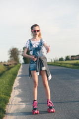Fototapeta premium Young girl riding on roller skates. Real people, authentic situations