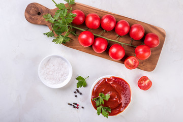 tomato sauce and fresh tomatoes on wooden board