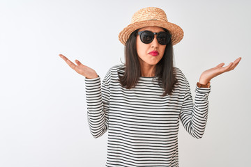Chinese woman wearing striped t-shirt hat sunglasses standing over isolated white background...