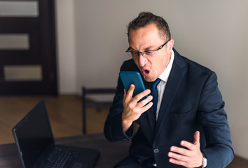 Businessman screaming on mobile phone. Reaction on failure.