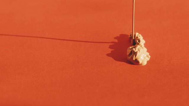concealer flows on red background. Make up and cosmetic concept. 4K slow motion