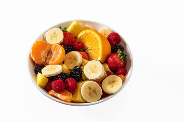 Delicious plate of mixed fruits, bananas, strawberries, tangerines, oranges, blackberries, berries and pineapple