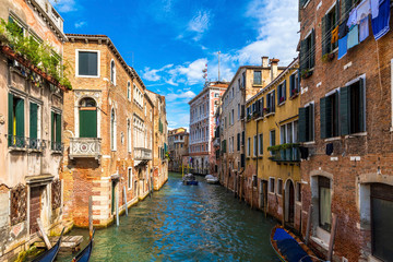 Fototapeta na wymiar Scenic canal with ancient buildings and boats in Venice. 