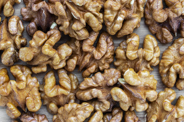 Unshelled walnuts background on brown wooden surface
