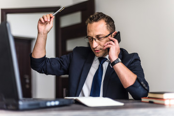 Young businessman working with laptop in an office.