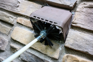 Dryer vent being cleaned with spinning brush