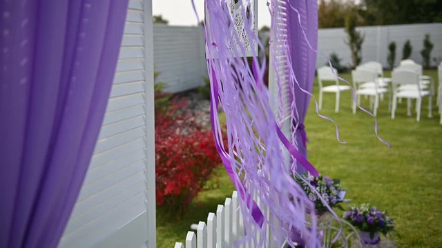 Wedding ceremony decoration on wind. Wind blows colorful ribbons in spring sunlight
