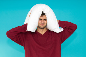 young man with pillow isolated on color background