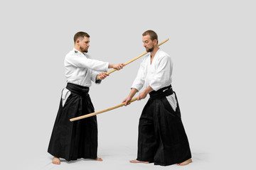 Two caucasian men are practicing aikido with Bokken (isolation path included)