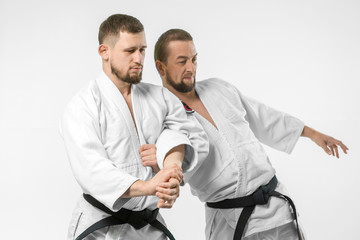 Two caucasian men are practicing aikido on the tatami (isolation path included)