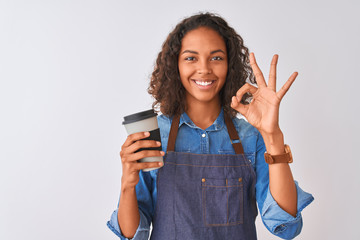 Young brazilian barista woman drinking take away coffee over isolated grey background doing ok sign...