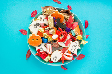 Halloween Jack o Lantern candy bowl with candy and halloween cookies Trick or Treat on blue background