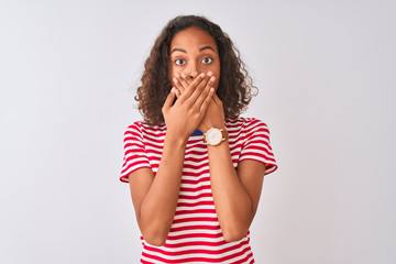 Young brazilian woman wearing red striped t-shirt standing over isolated white background shocked covering mouth with hands for mistake. Secret concept.