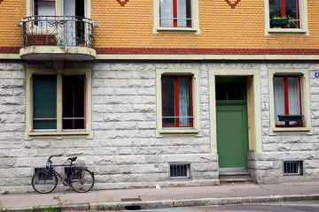 Fototapeta na wymiar bicycle parked against beautiful residential decorated orange building with terrace 