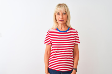 Middle age woman wearing casual striped t-shirt standing over isolated white background Relaxed with serious expression on face. Simple and natural looking at the camera.