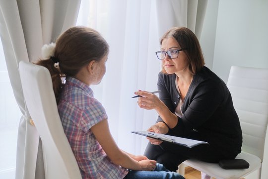 Woman social worker talking to girl. Child psychology, mental health