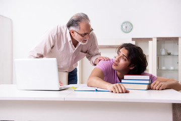 Old father helping his son in exam preparation