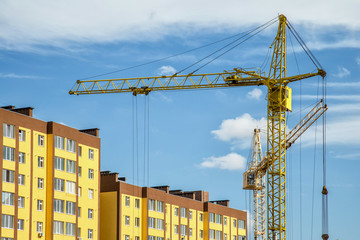 Building crane and buildings under construction against evening sky,House under construction. Industrial skyline