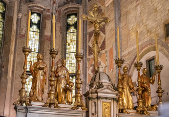 Detail of golden sculptures of saints decorating altar inside catholic church 