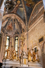 Golden sculptures of saints decorating altar in catholic church in Italy