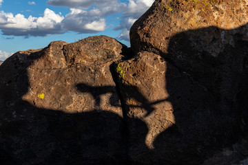A shadow of a person climbing on big boulders in the desert - 292760850