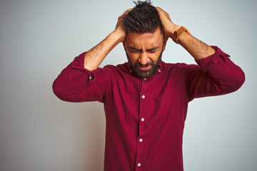 Young indian man wearing red elegant shirt standing over isolated grey background suffering from...