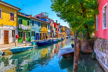 Street with colorful buildings and canal in Burano island, Venice, Italy. Architecture and...