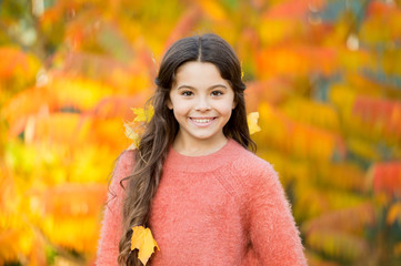 Autumn brings happiness and joy. Happy little girl wear autumn leaves in hair. Small child happy...