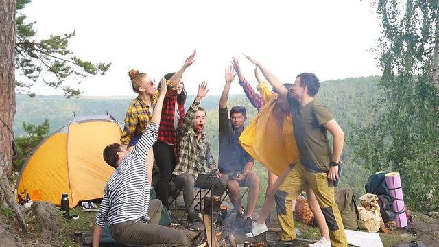 Positive cheerful young people keeping hands together, expressing team, friendship, teambuilding. Slow motion