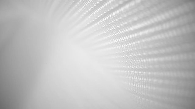Shiny net cloth flowing texture dolly shot in close up view macro. Wavy clean silk weave material. Textile abstract background. Bed sheet, curtain and clothing industry concept.