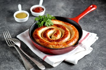 Grilled sausage in a cast iron pan. Delicious homemade food.