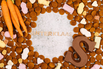 Concept for children party in Saint Nicolas day five december. Background with traditional food - pepernoten, chocolate letter, sweets strooigoed and carrots for horse. Dutch holiday Sinterklaas. 