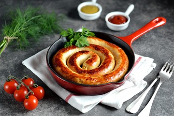 Grilled sausage in a cast iron pan. Delicious homemade food.