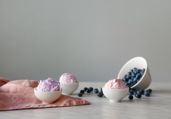 Bowls with tasty blueberry ice cream on light table