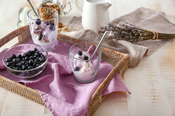 Obraz na płótnie Canvas Tray with tasty ice cream and blueberry on white table