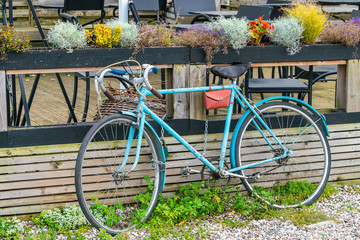 Fototapeta premium An old blue bike is parked at a closed cafe. Forgotten bike.