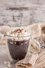 Cup of hot chocolate with marshmallows on light background